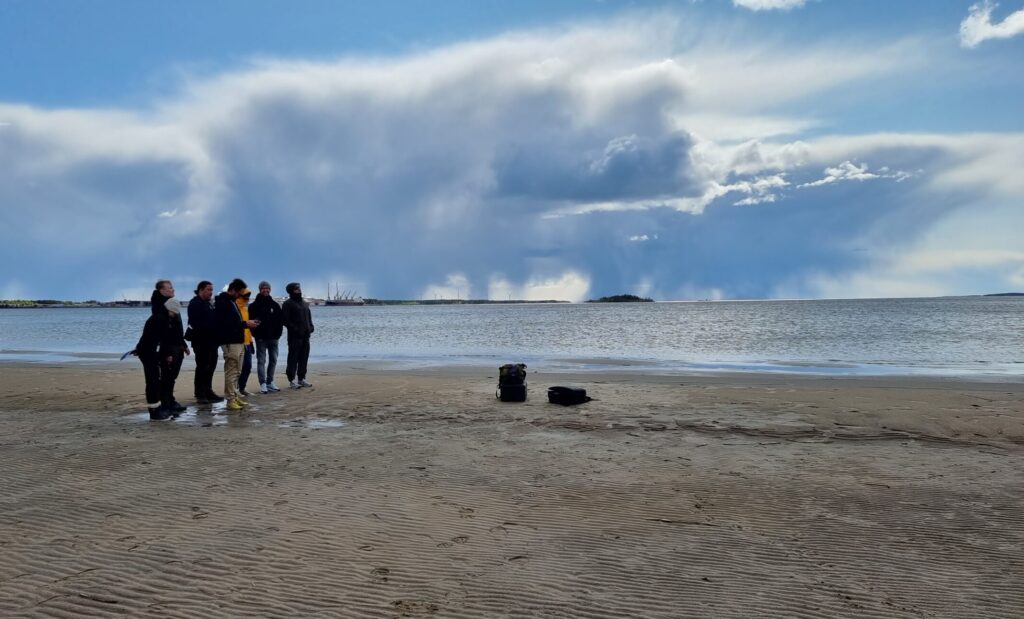 A group of people standing together and looking at a flying drone