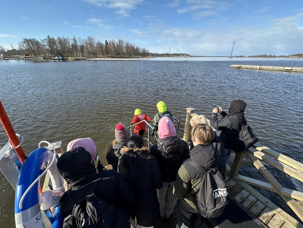 People standing on the dock by the water's edge