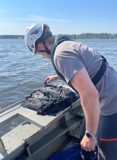 Person investigating sediment sample on a boat